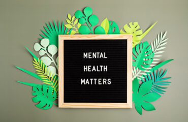 Mental health matters motivational quote on the letter board. Inspirational text with paper cut leaves bordering letter board.